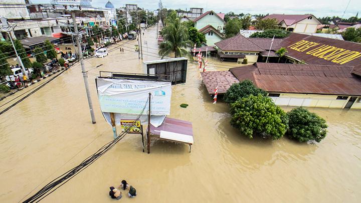 Sejumlah warga berjalan menembus banjir saat banjir melanda Kota Lhoksukon, Aceh Utara, Aceh, Senin, 3 Januari 2022. Data dari BPBD Aceh Utara mencatat banjir yang merendam 14 Kecamatan di daerah tersebut mengakibatkan 2.278 jiwa terdampak. ANTARA/Rahmad