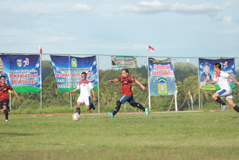 Pj Bupati Aceh Besar Muhammad Iswanto saat melepaskan diri dari kawalan sejumlah pemain Lanud SIM pada laga dimenangkan Aceh Beasr 2-0, dalam laga persahabatan kedua tim di Jantho Sport Center (JSC) Stadium, Kota Jantho, Rabu (30/08/2023) petang.  FOTO/ PROKOPIM ACEH BESAR
